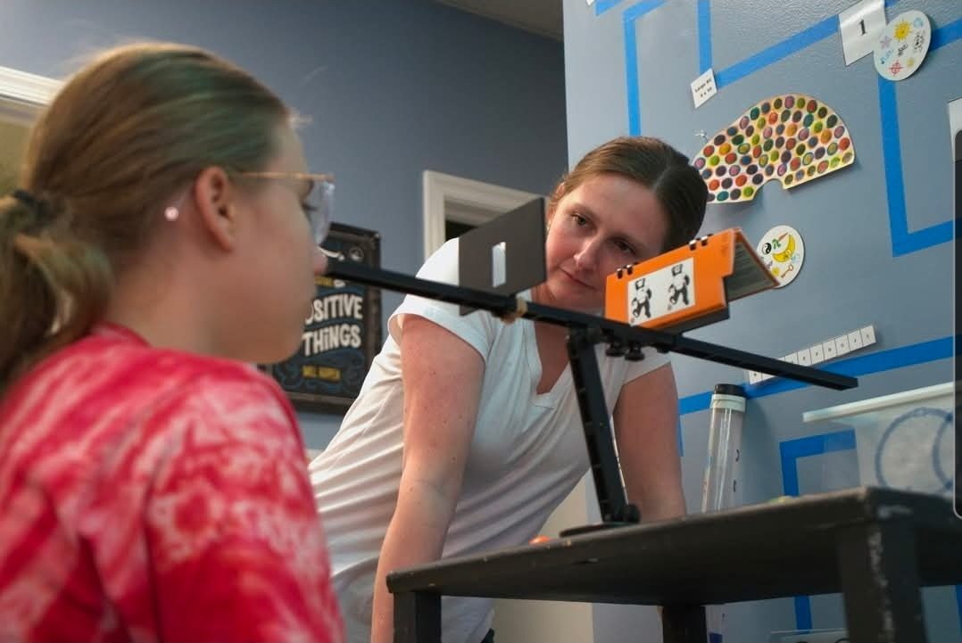 Meghan Schneider guiding a young client through a vision rehabilitation exercise